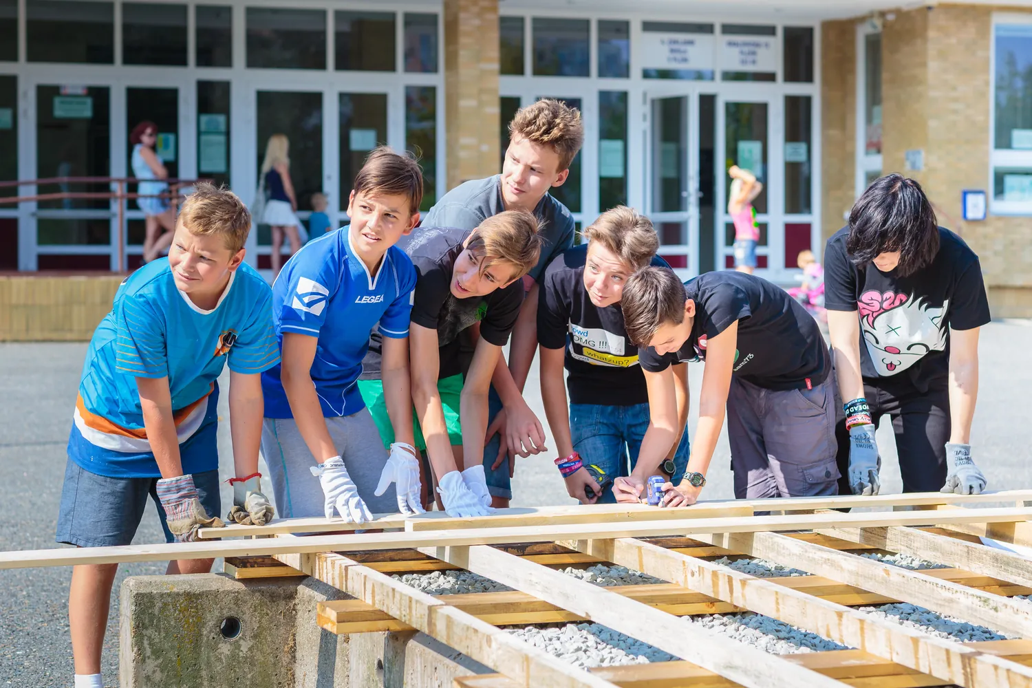 Local schoolchildren helping build the deck frame in front of the school