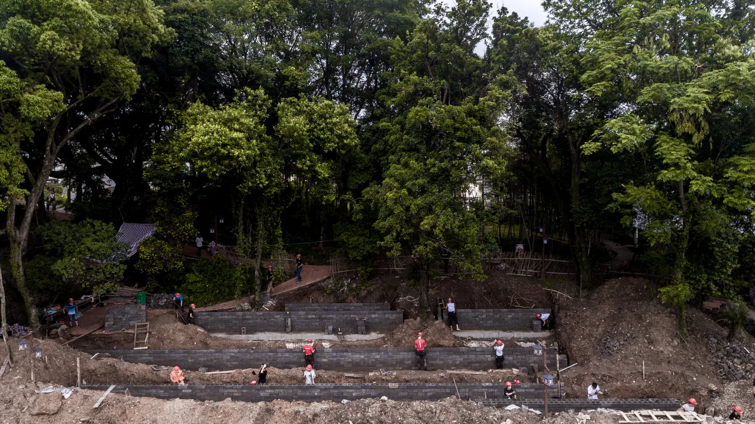 Wide view of terraced retaining walls with students working along them
