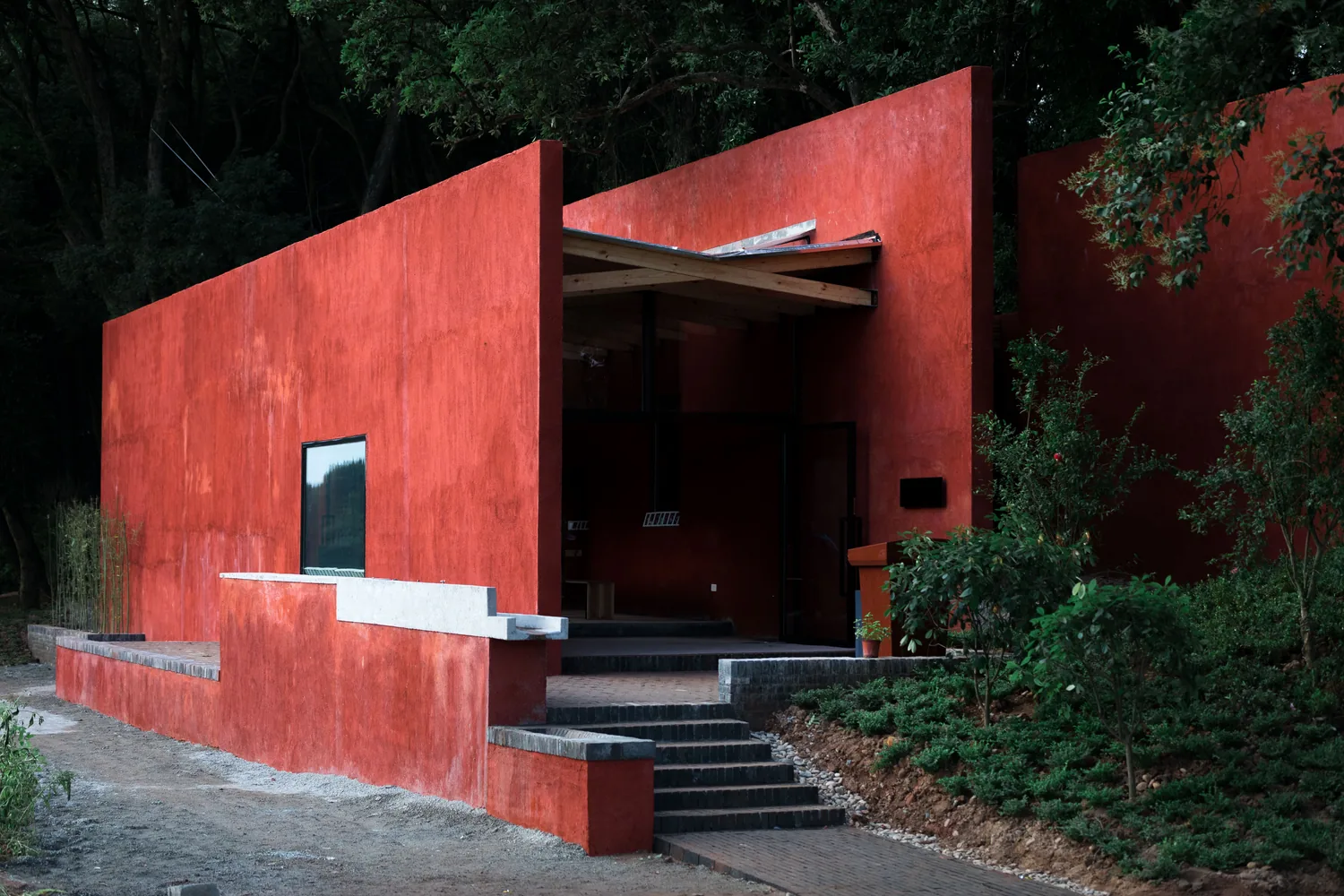 Entrance of the finished red building with timber roof and steps